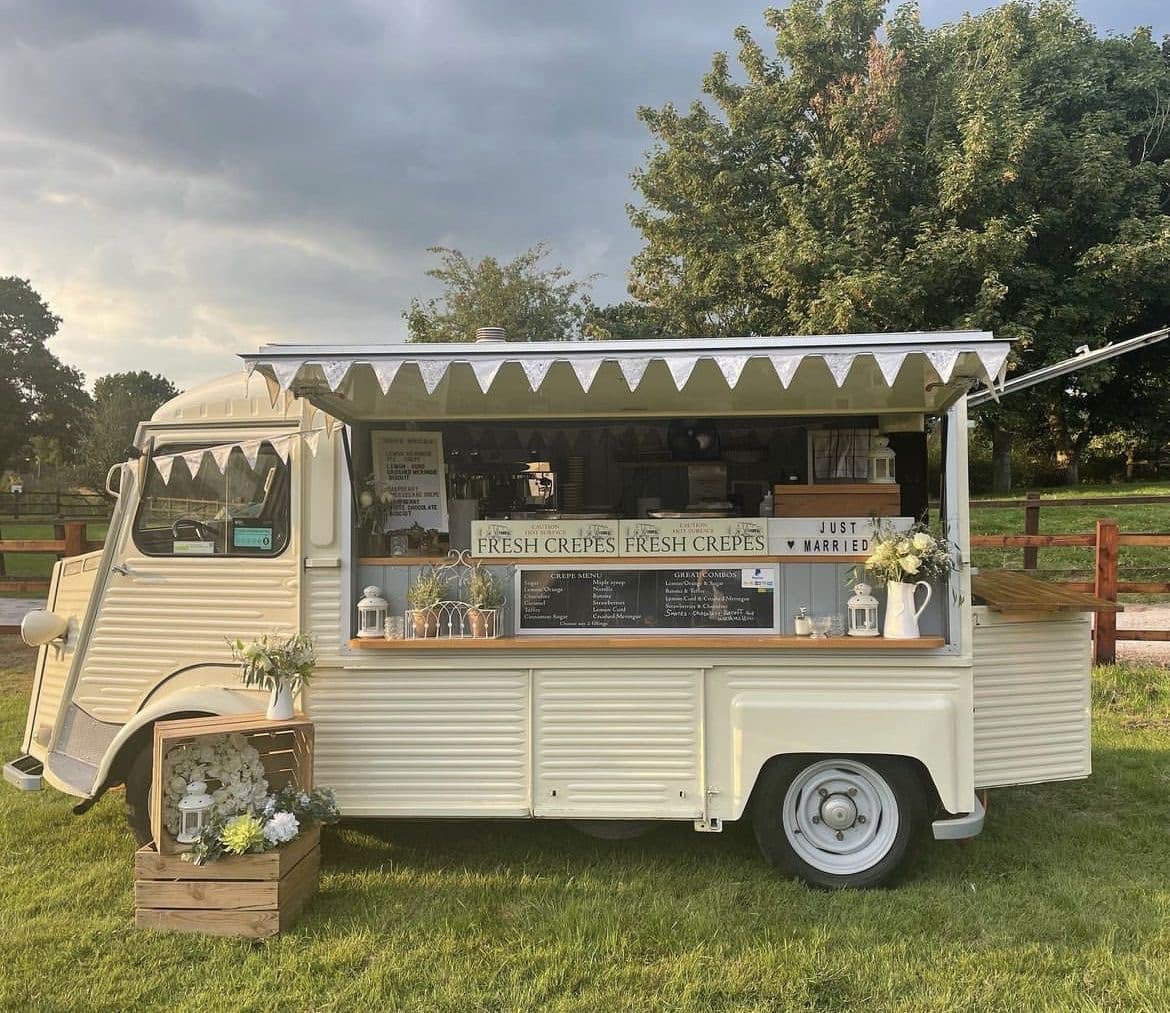 Food truck clásico en jardín de boda al atardecer