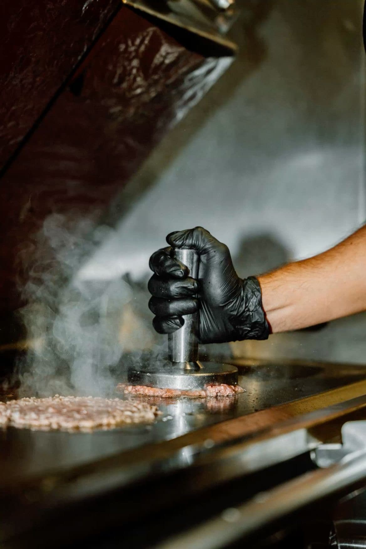 Chef haciendo smash burger en plancha con show cooking en directo